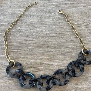 Grey tortoise and brass necklace.